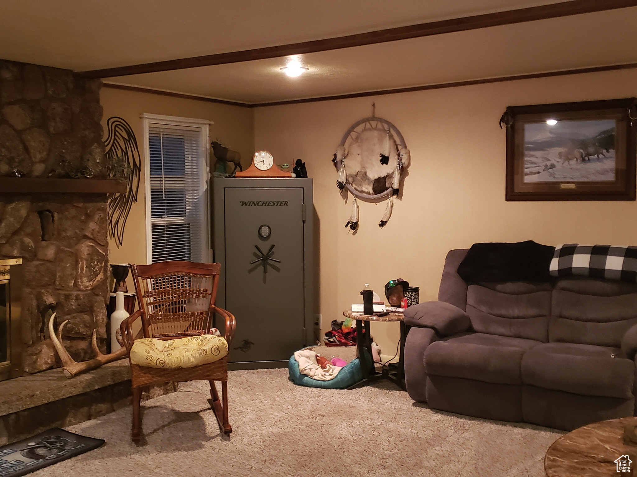 Carpeted living room with a stone fireplace.