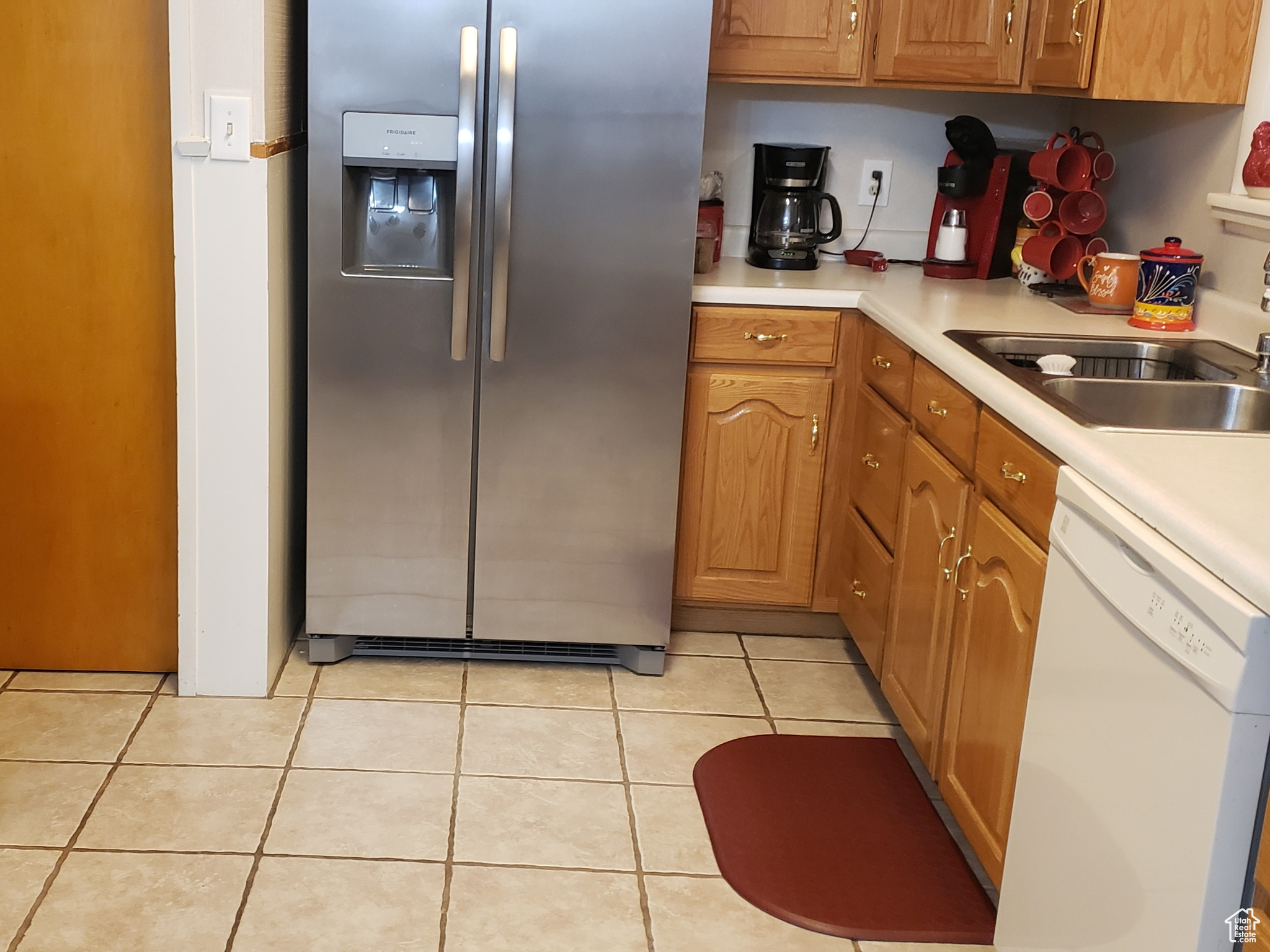 Kitchen featuring sink, light tile patterned floors, and appliances with stainless steel finishes