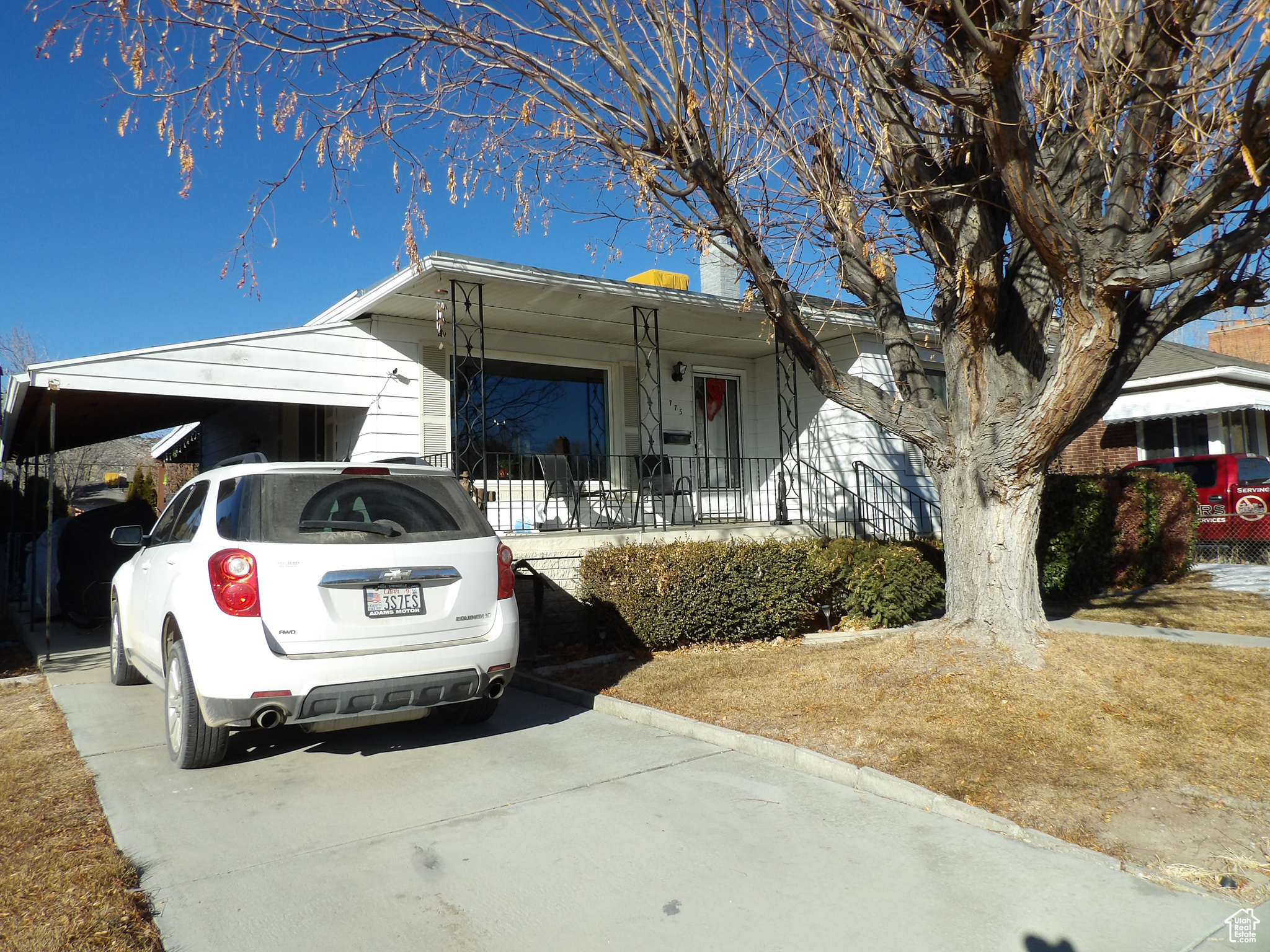 View of front of home with a porch and a carport