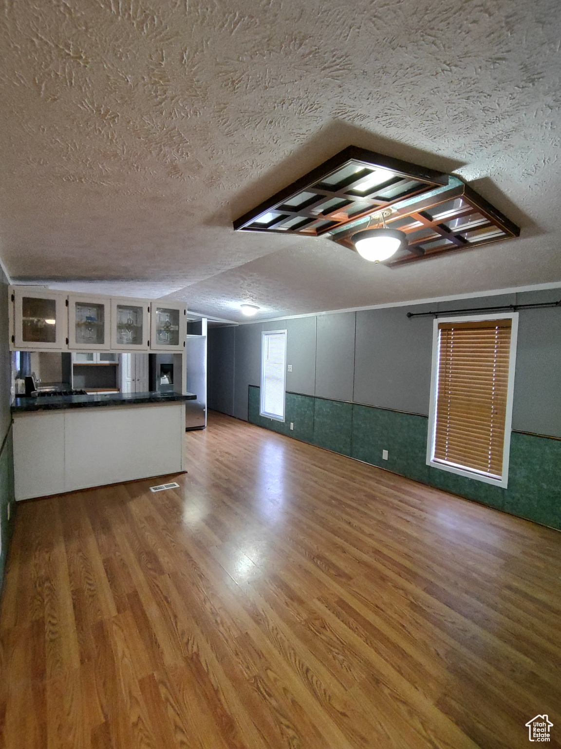 Unfurnished living room featuring wood-type flooring and a textured ceiling