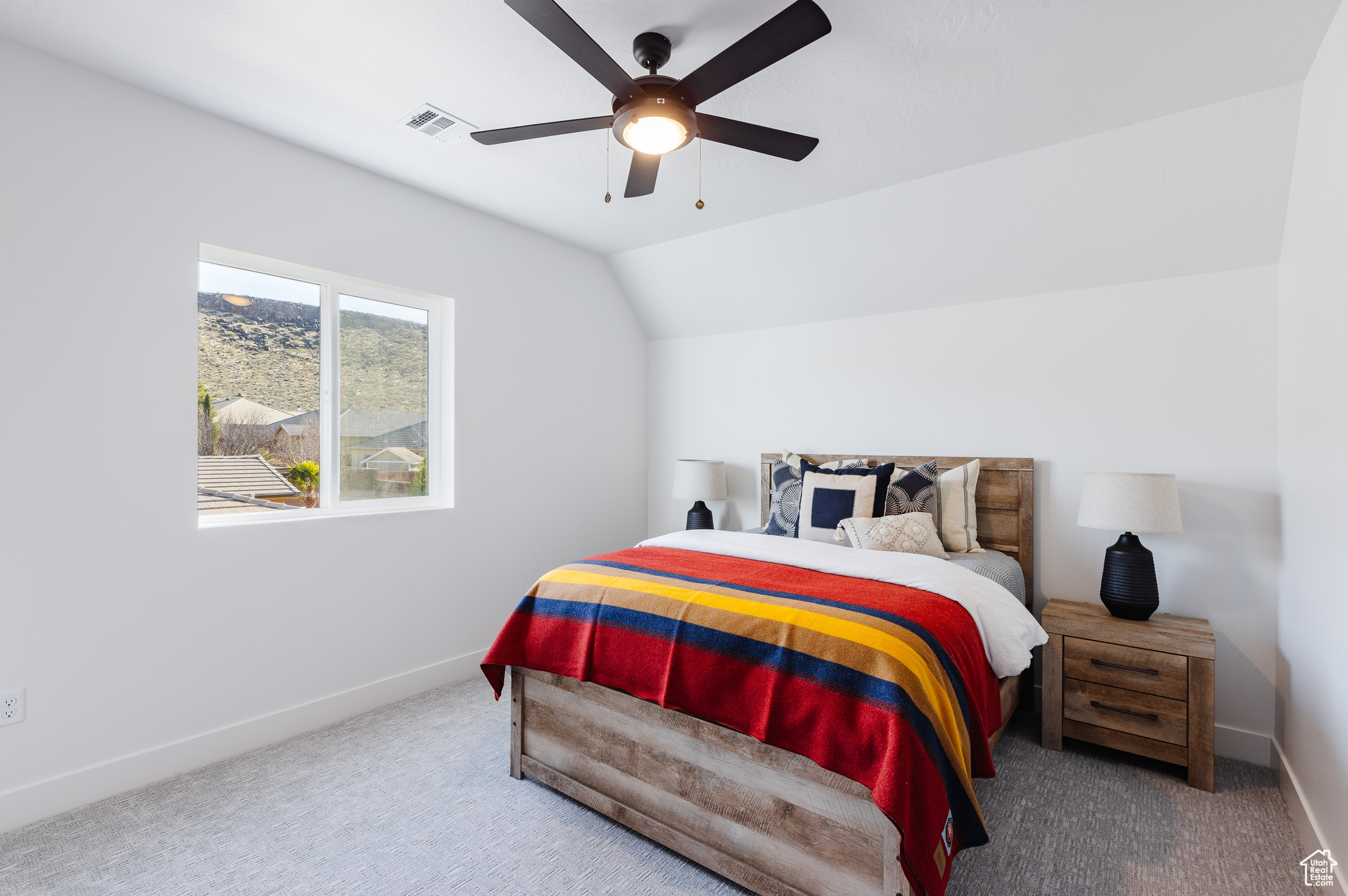 Bedroom with carpet flooring, ceiling fan, and vaulted ceiling
