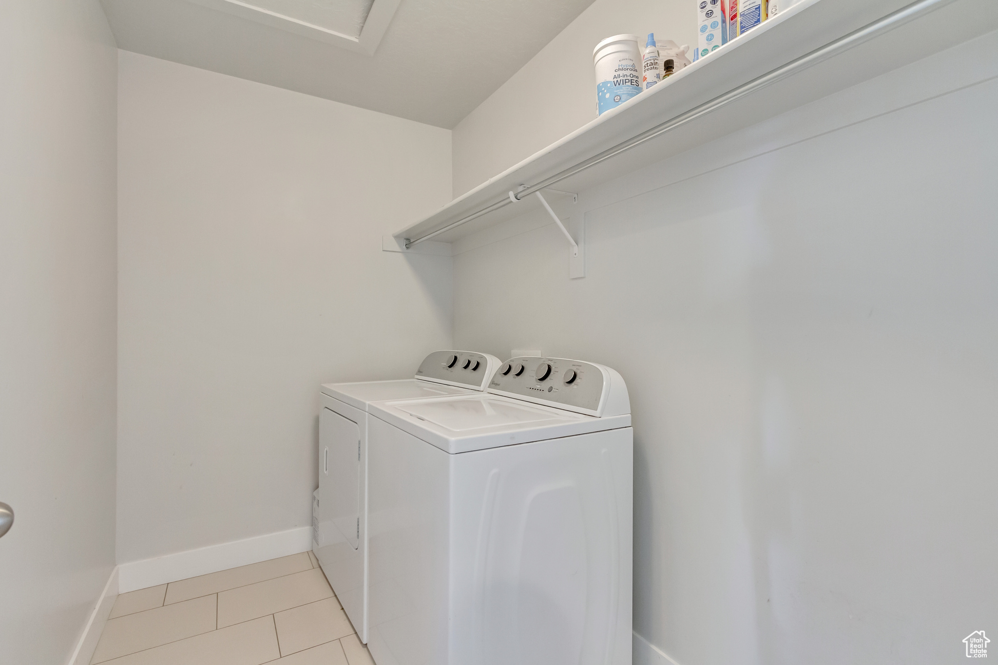 Laundry room featuring washer and clothes dryer and light tile patterned flooring