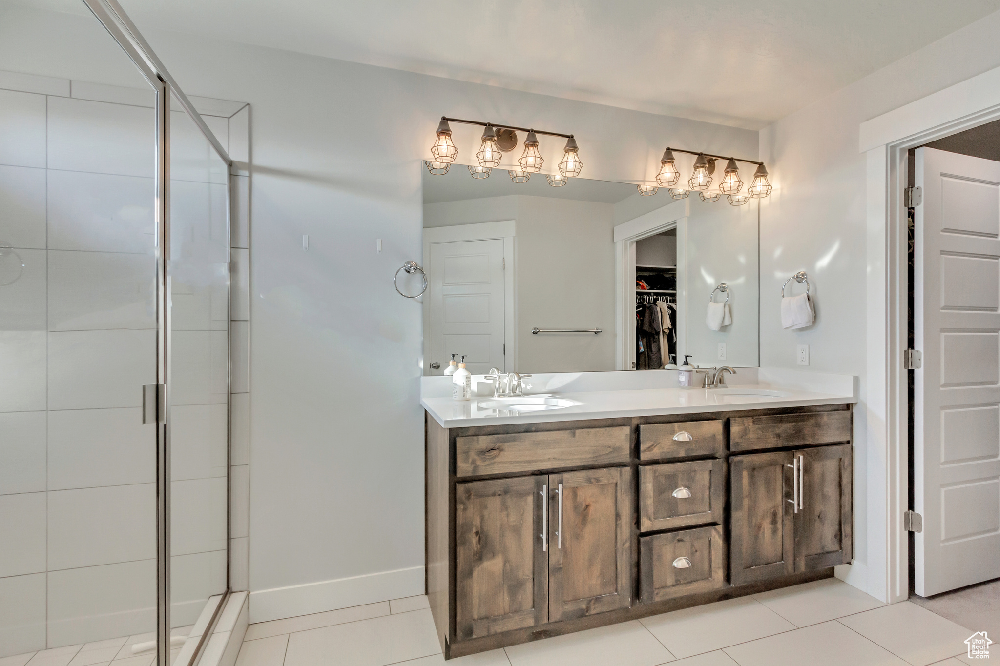 Bathroom featuring vanity, a shower with door, and tile patterned flooring