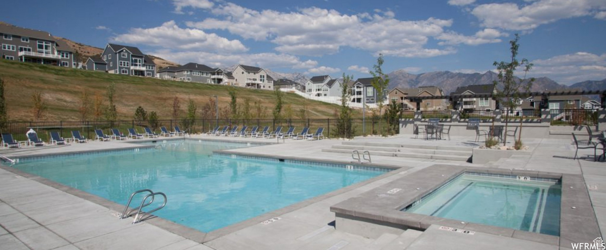 View of pool with a mountain view, a patio, and a hot tub