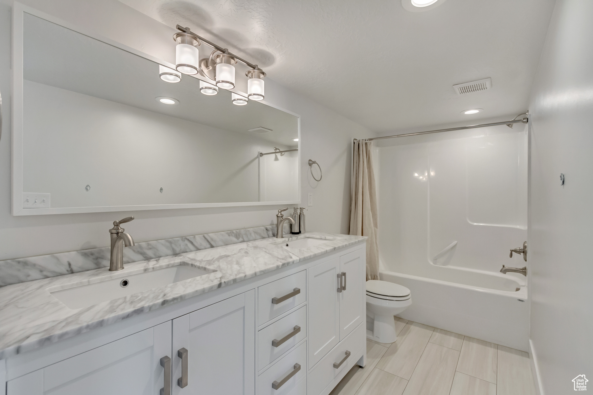 Full bathroom featuring toilet, shower / tub combo, and vanity