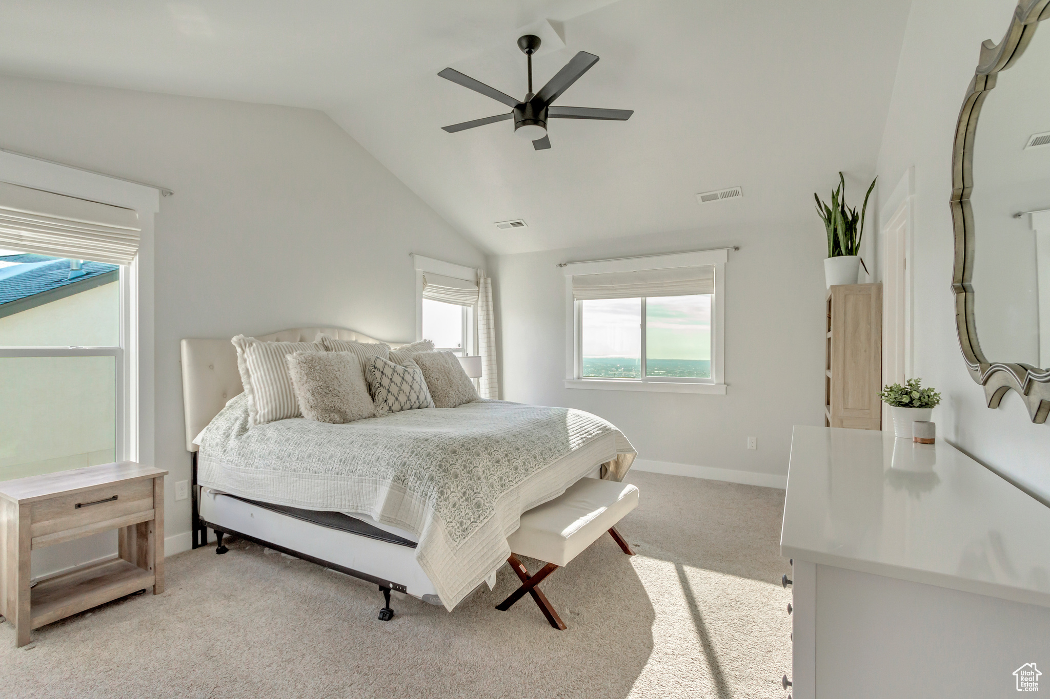 Bedroom featuring ceiling fan, vaulted ceiling, and light colored carpet