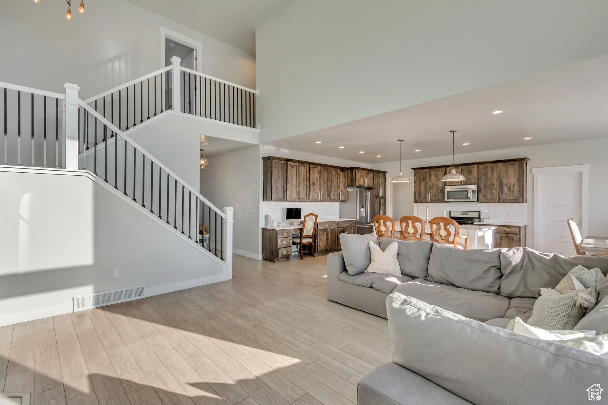 Living room featuring a high ceiling and light hardwood / wood-style floors