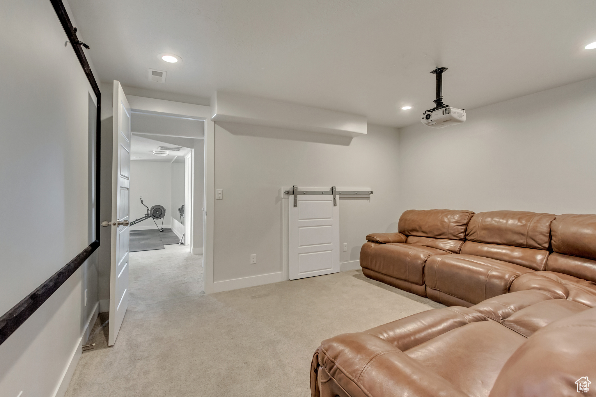 Carpeted home theater featuring a barn door