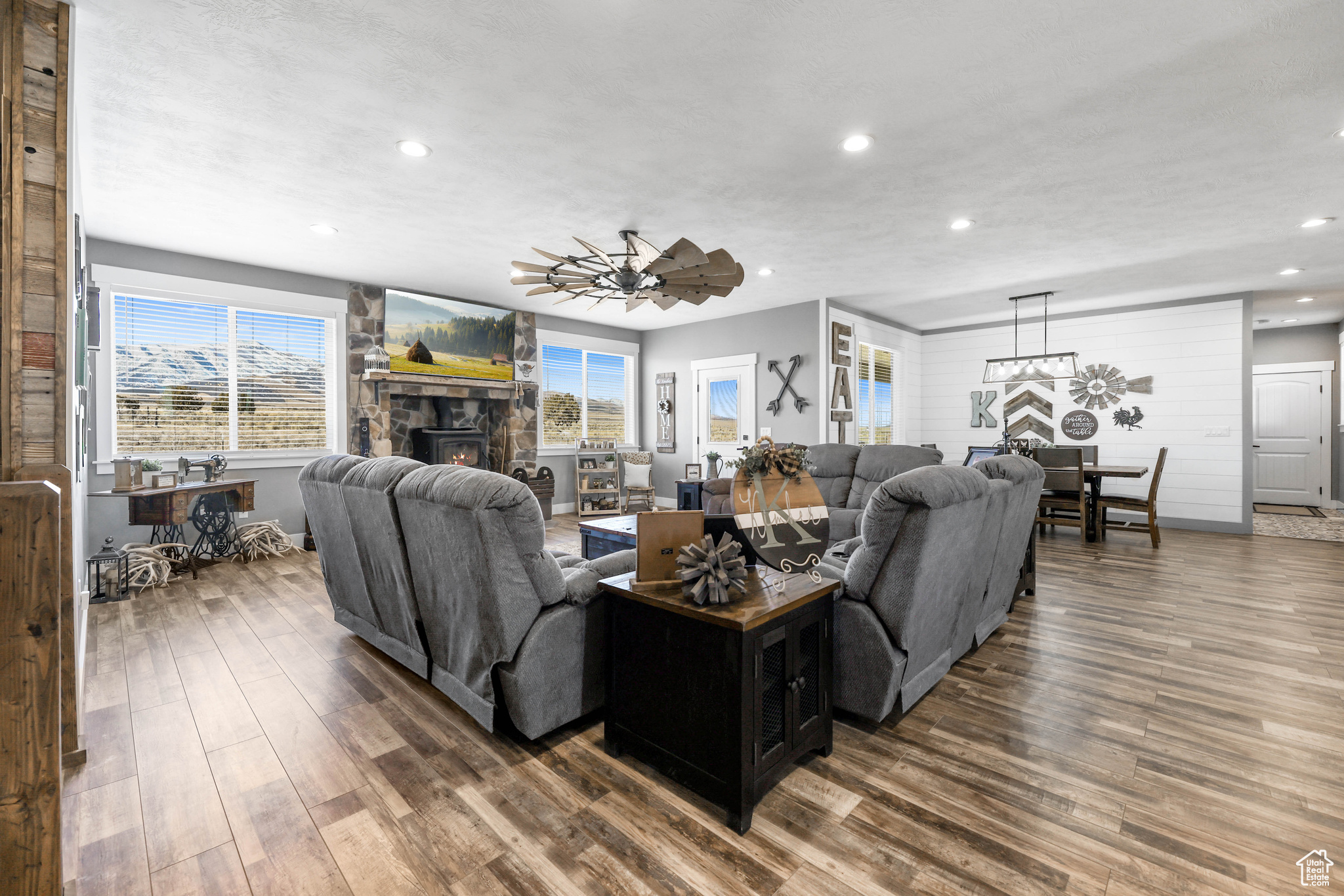 Living room featuring ceiling fan, a fireplace, and hardwood / wood-style floors