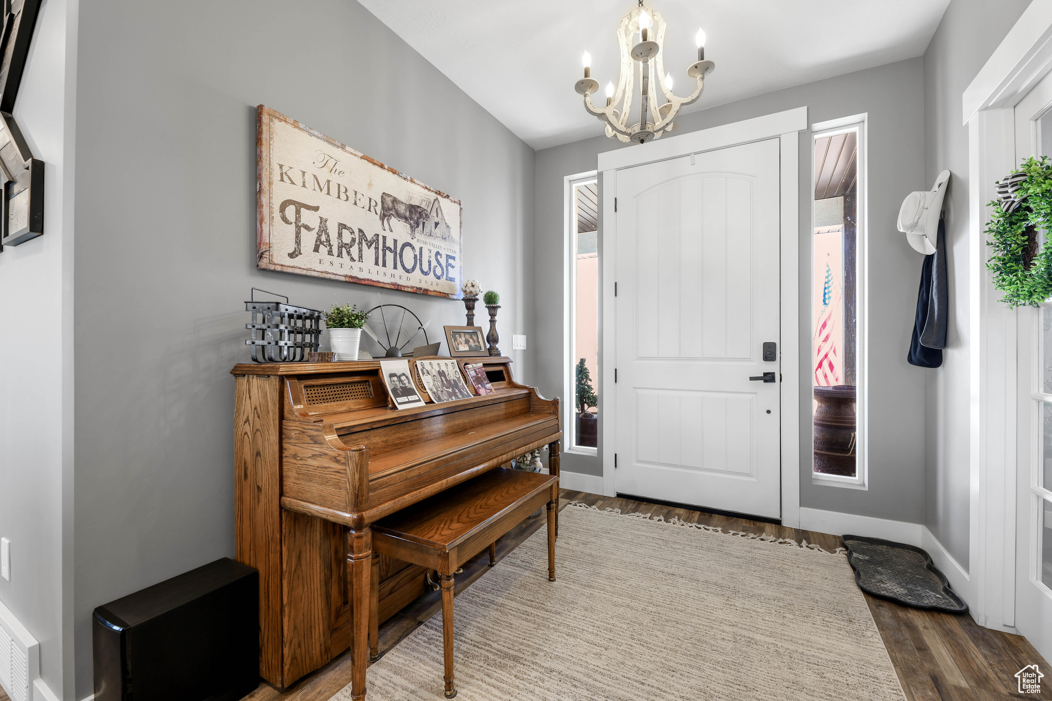 Foyer entrance with wood-type flooring and an inviting chandelier