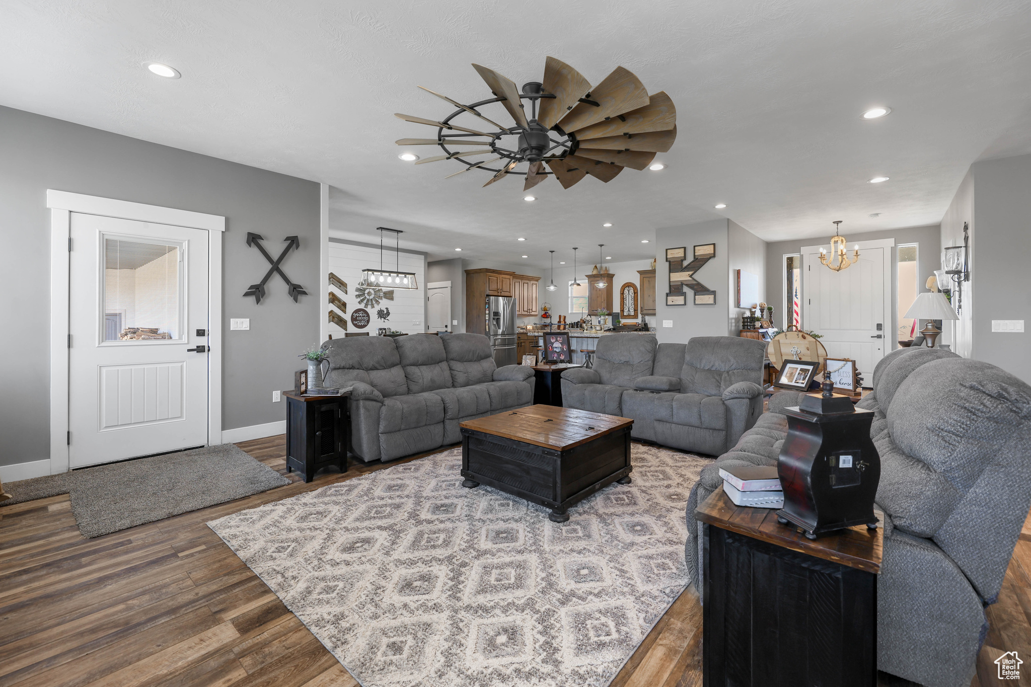 Living room featuring wood-type flooring and ceiling fan with notable chandelier
