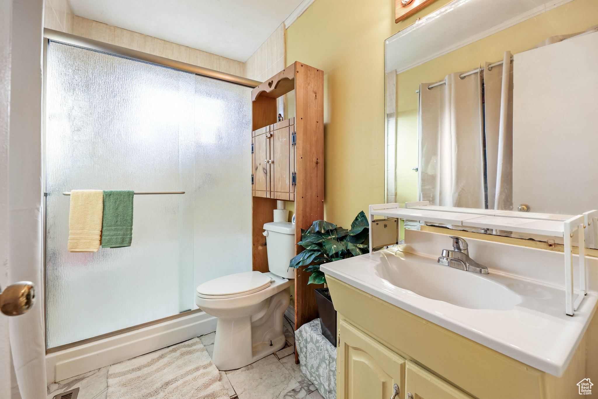 Bathroom with vanity, toilet, and an enclosed shower