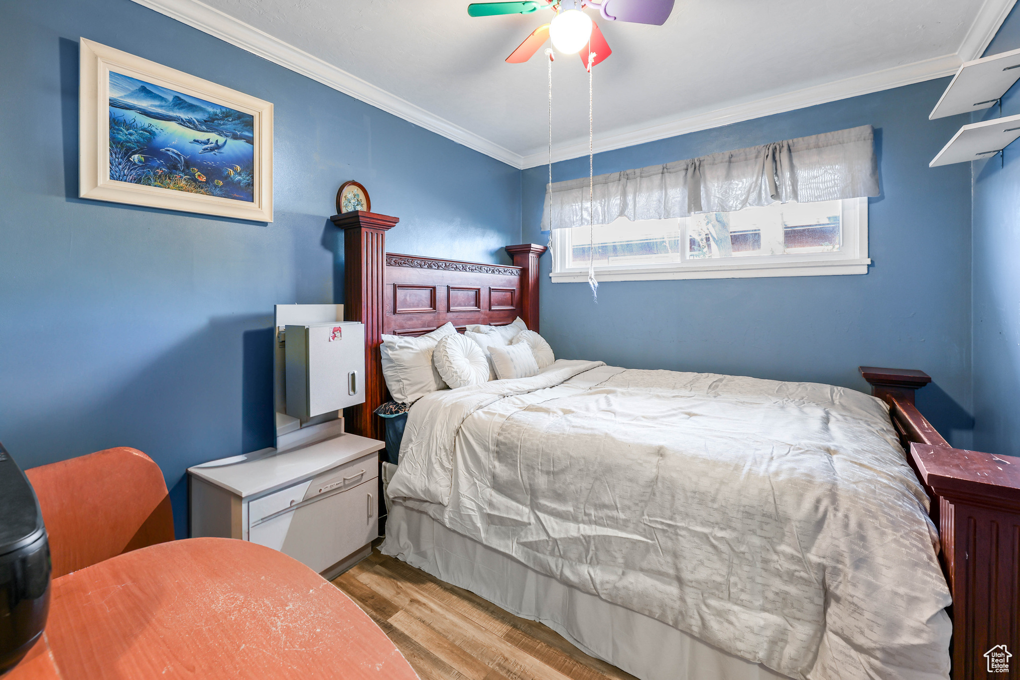 Bedroom featuring ceiling fan, crown molding, and light hardwood / wood-style floors