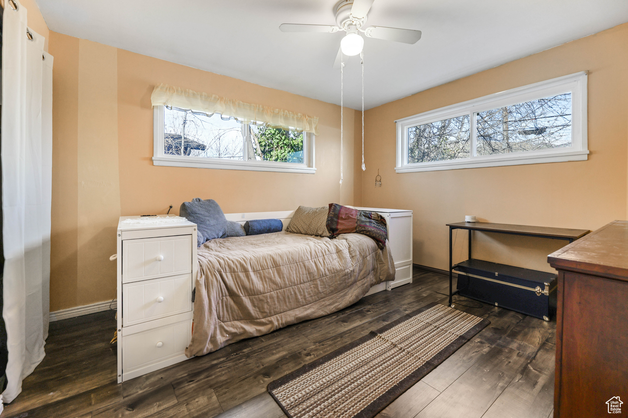 Bedroom featuring ceiling fan, dark wood-type flooring, and multiple windows
