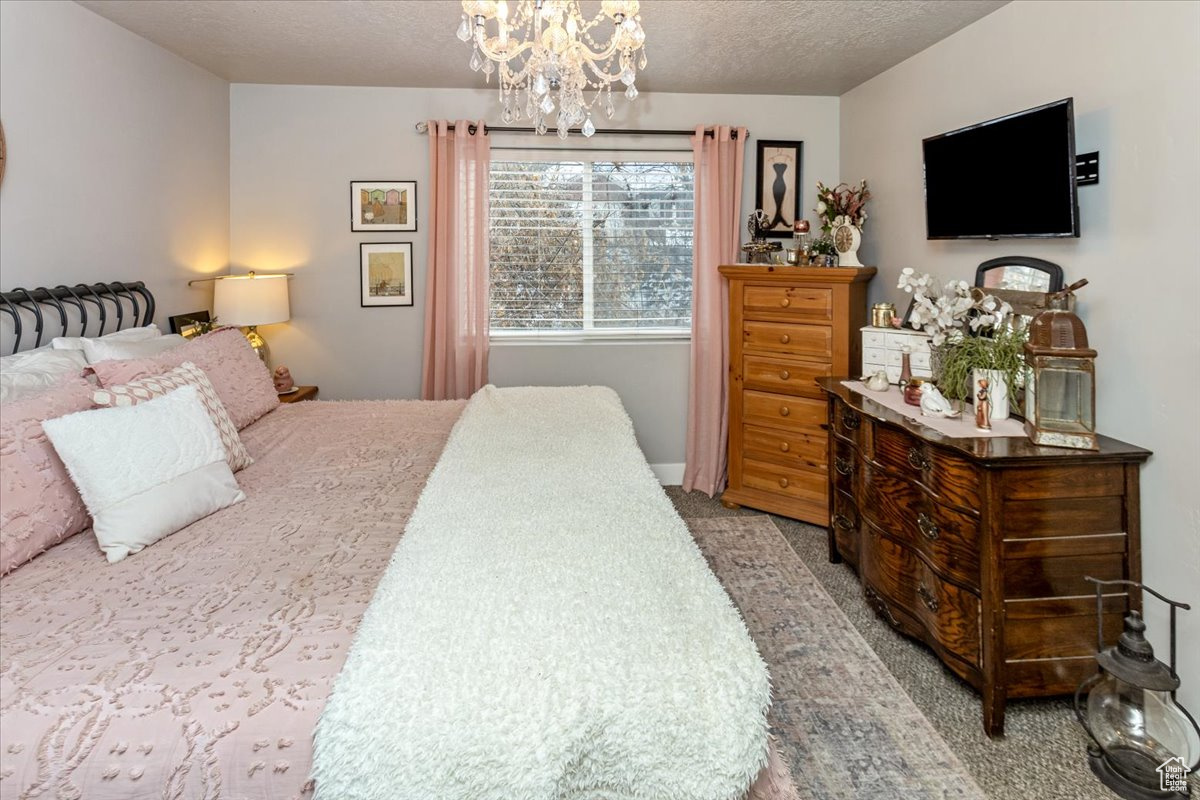 Bedroom with light carpet, a textured ceiling, and lots of natural light