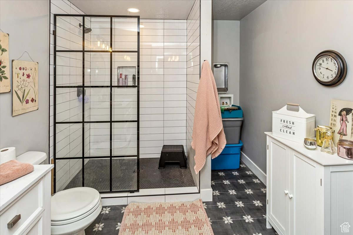 ADU Bathroom with a tile shower, vanity, and toilet