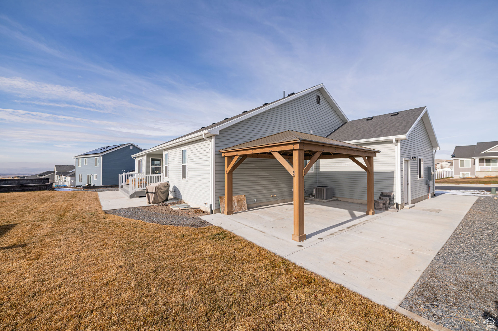 Rear view of property with a gazebo, a patio, cooling unit, and a lawn