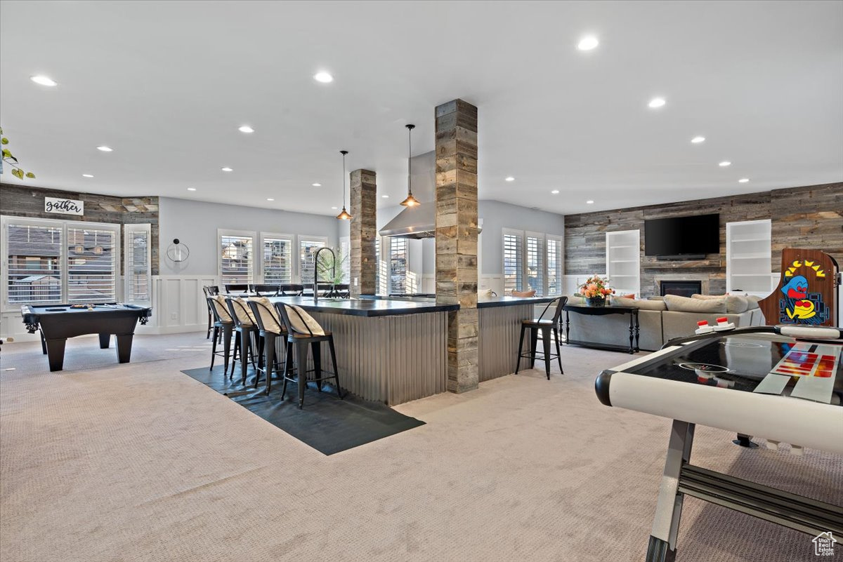 Kitchen featuring decorative light fixtures, a healthy amount of sunlight, a kitchen breakfast bar, and pool table