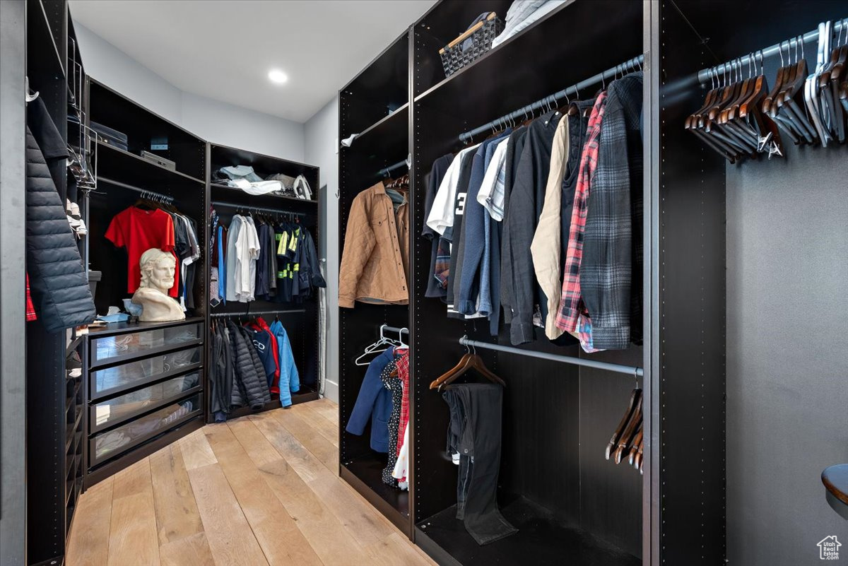 Walk in closet with wood-type flooring