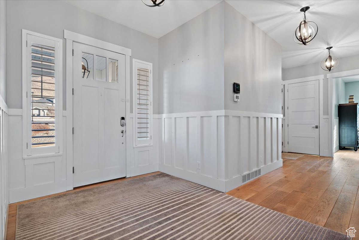 Foyer featuring light hardwood / wood-style floors and an inviting chandelier