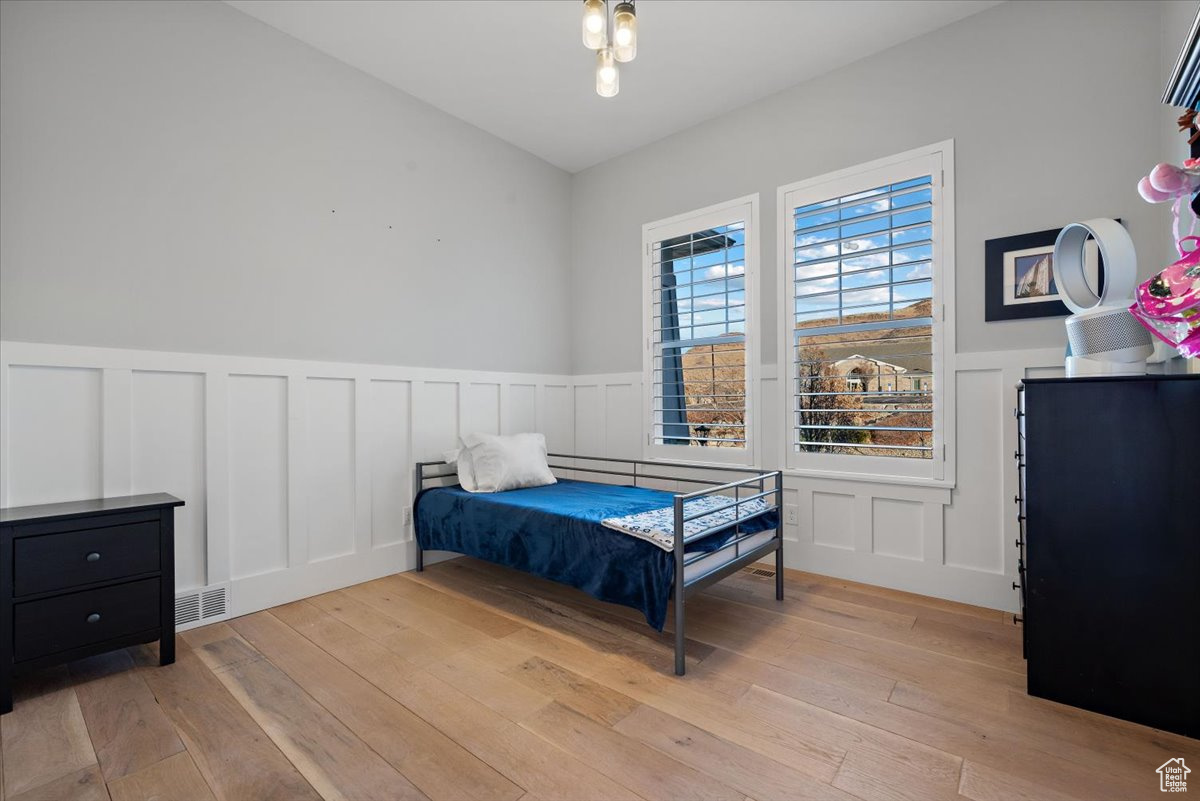 Bedroom with light hardwood / wood-style flooring and lofted ceiling