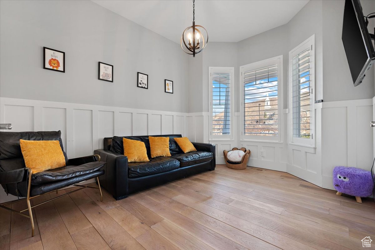 Sitting room with a chandelier and light hardwood / wood-style floors