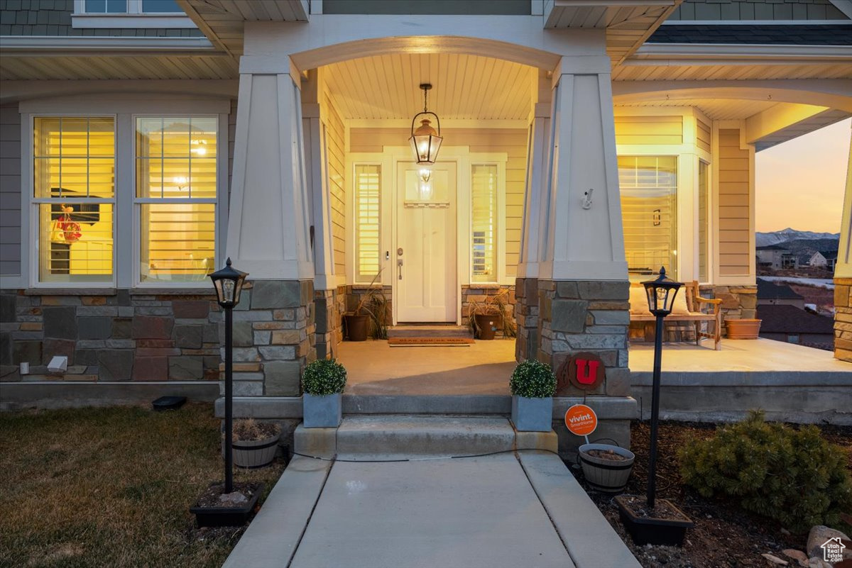 Exterior entry at dusk featuring covered porch