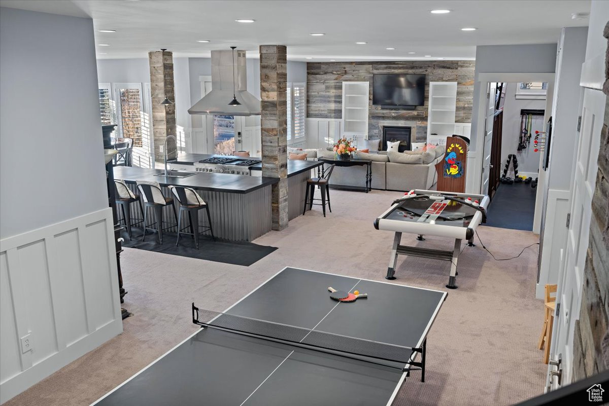 Game room featuring sink, light colored carpet, and a fireplace