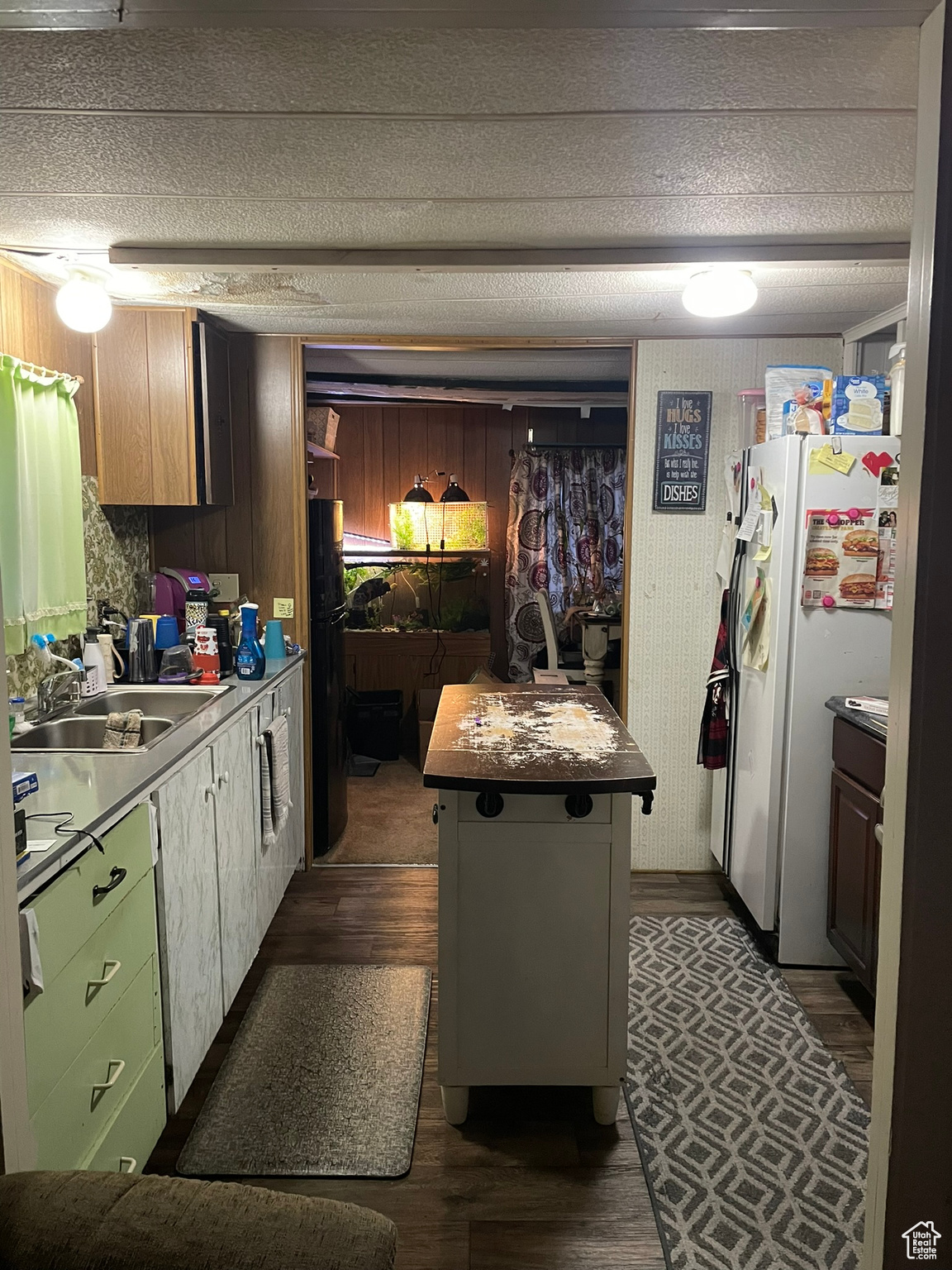 Kitchen featuring sink, white refrigerator, a center island, dark hardwood / wood-style floors, and green cabinets