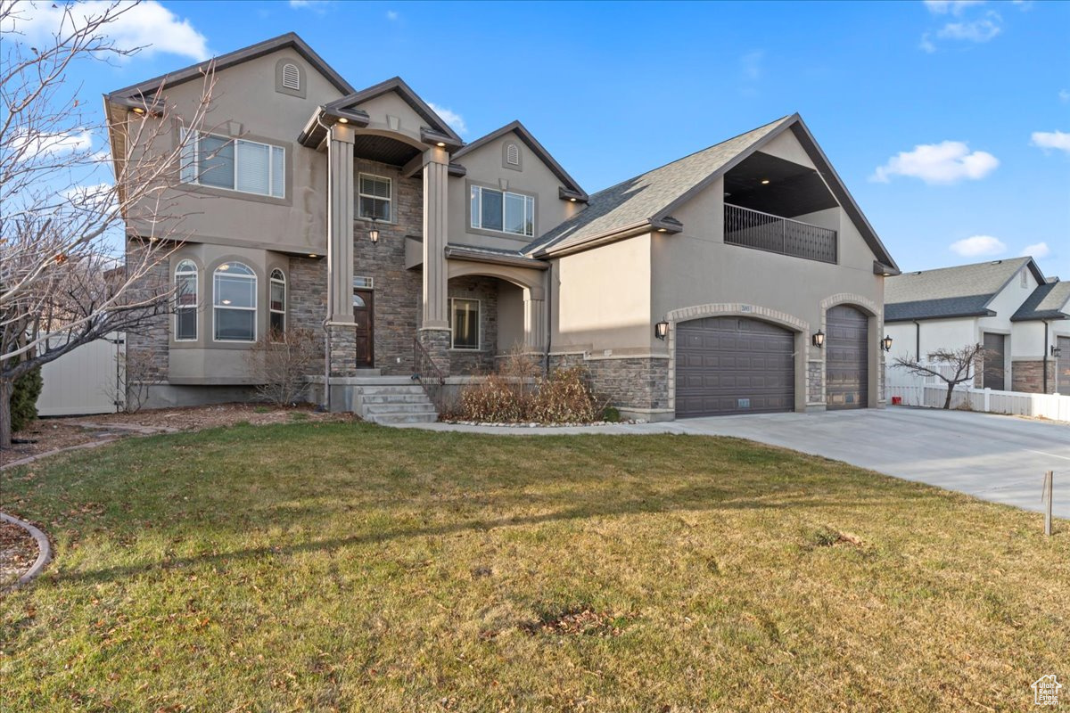 View of front of home with a garage and a front lawn