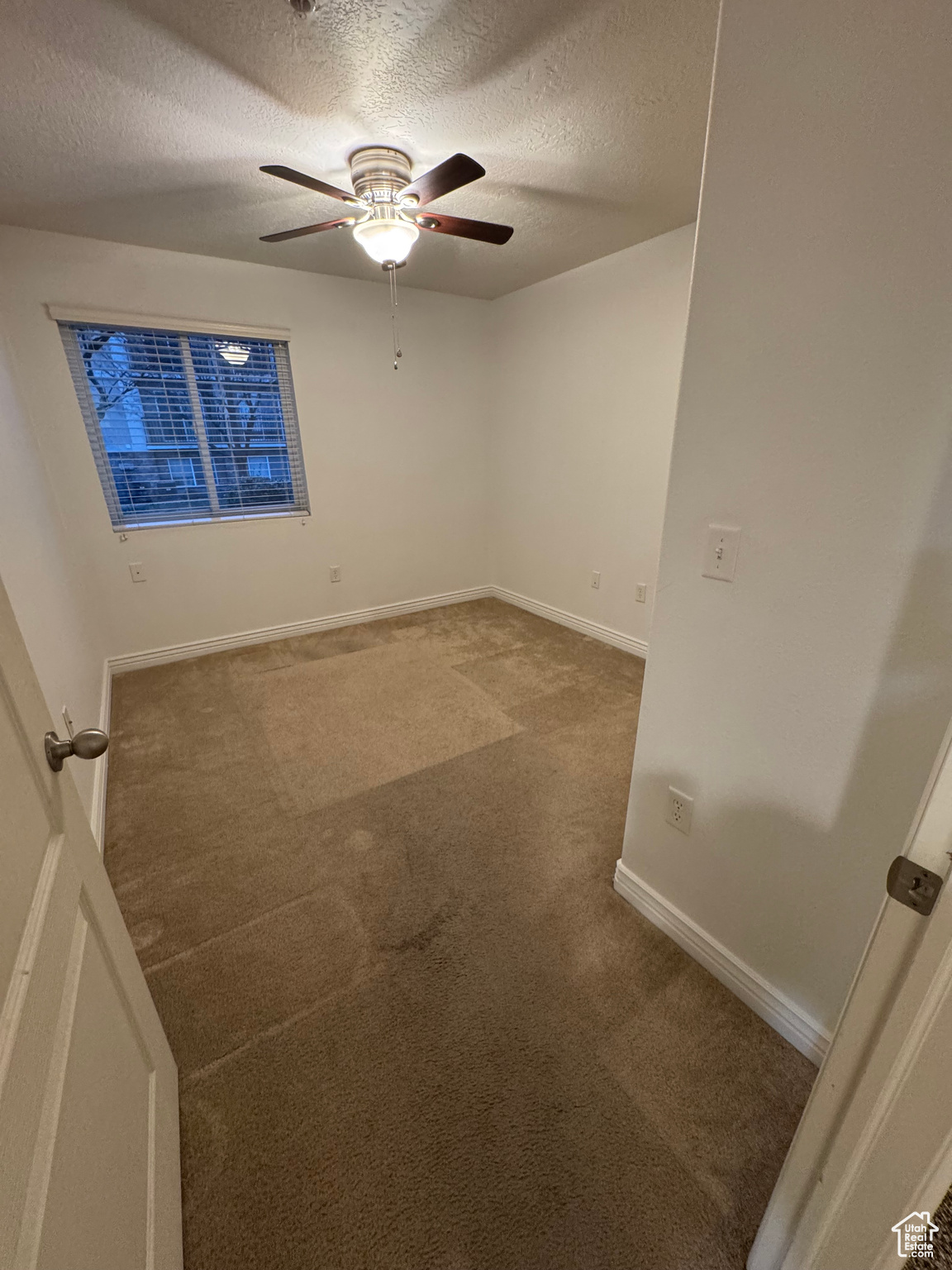 Unfurnished room featuring carpet, a textured ceiling, and ceiling fan