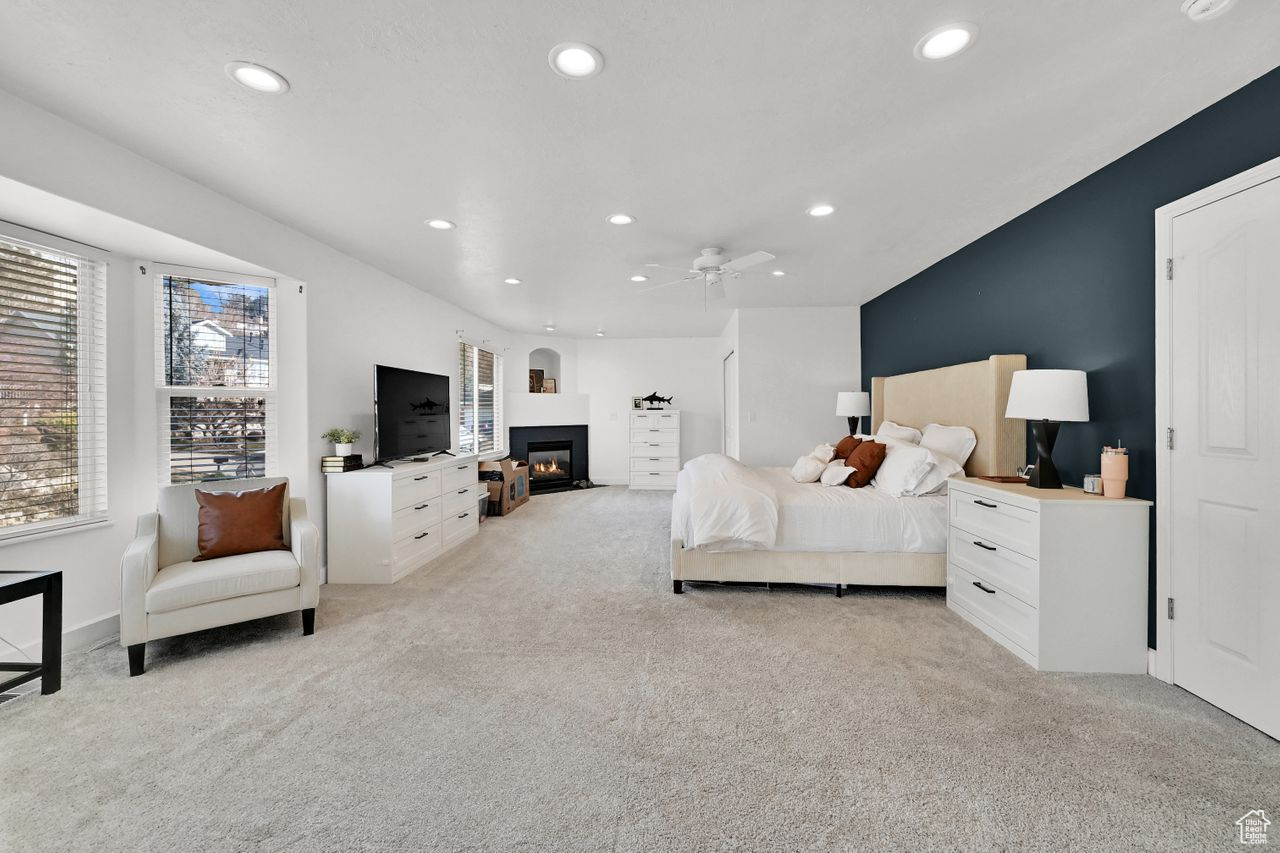 Carpeted bedroom featuring ceiling fan