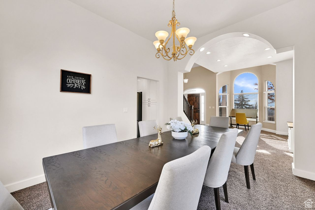 Carpeted dining space featuring a notable chandelier