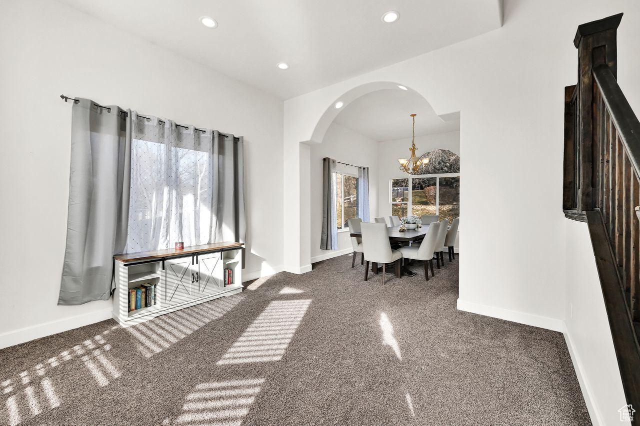 Unfurnished dining area with a chandelier and carpet floors