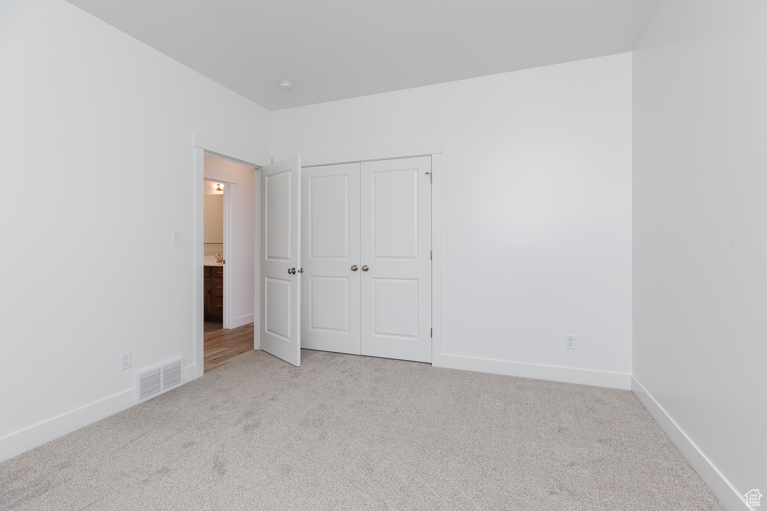 Unfurnished bedroom with a closet and light colored carpet