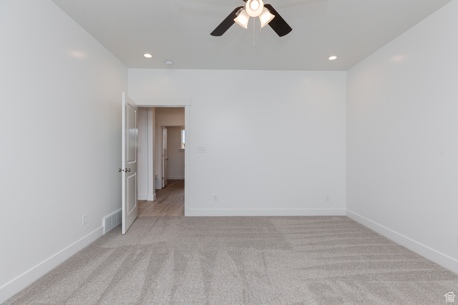 Spare room with ceiling fan and light colored carpet