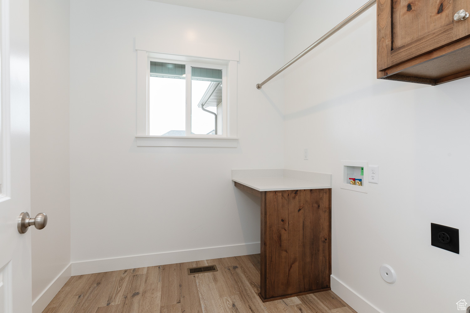 Laundry area featuring gas dryer hookup, cabinets, hookup for a washing machine, hookup for an electric dryer, and light hardwood / wood-style floors