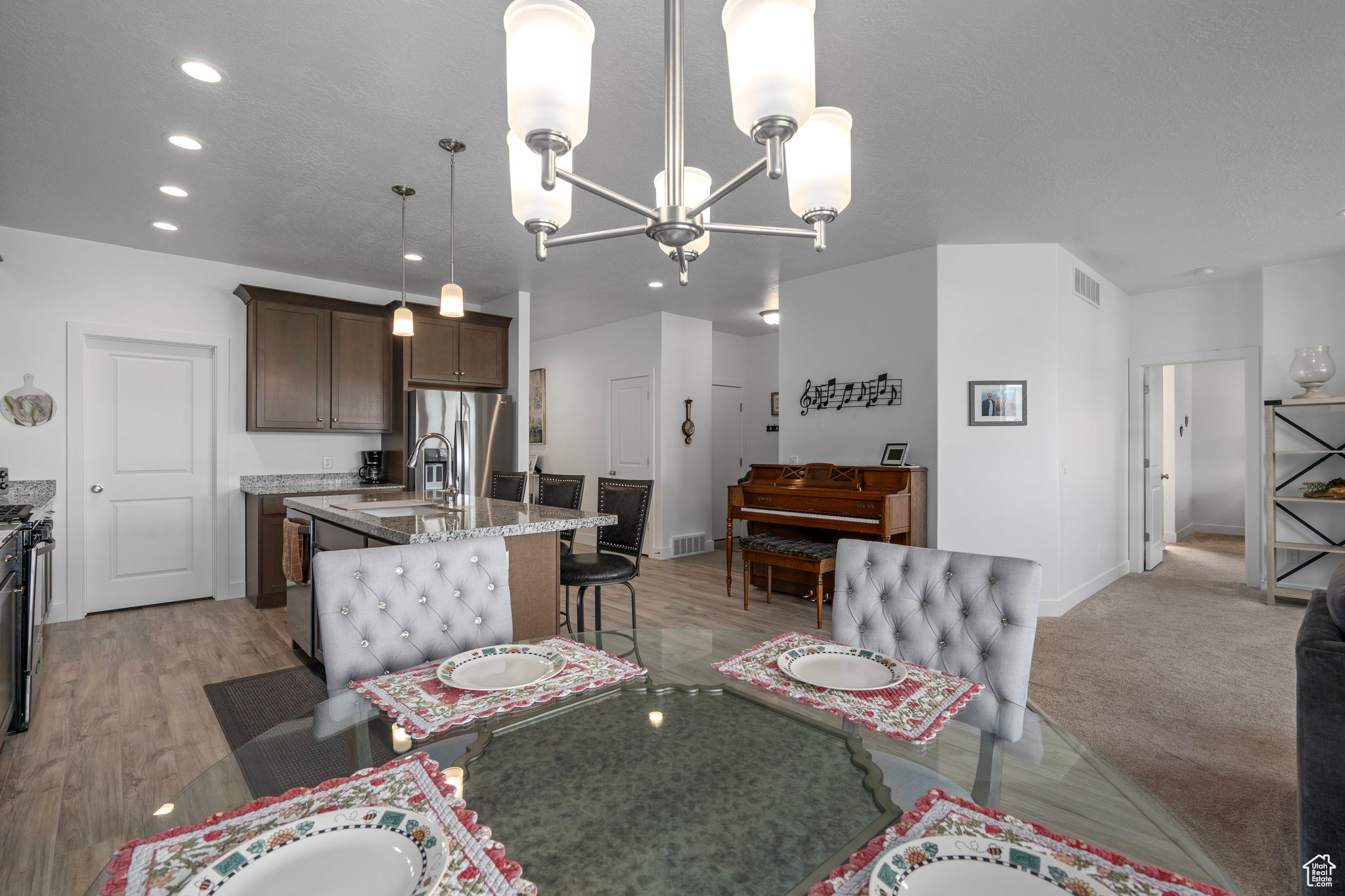 Carpeted dining area with a notable chandelier and sink