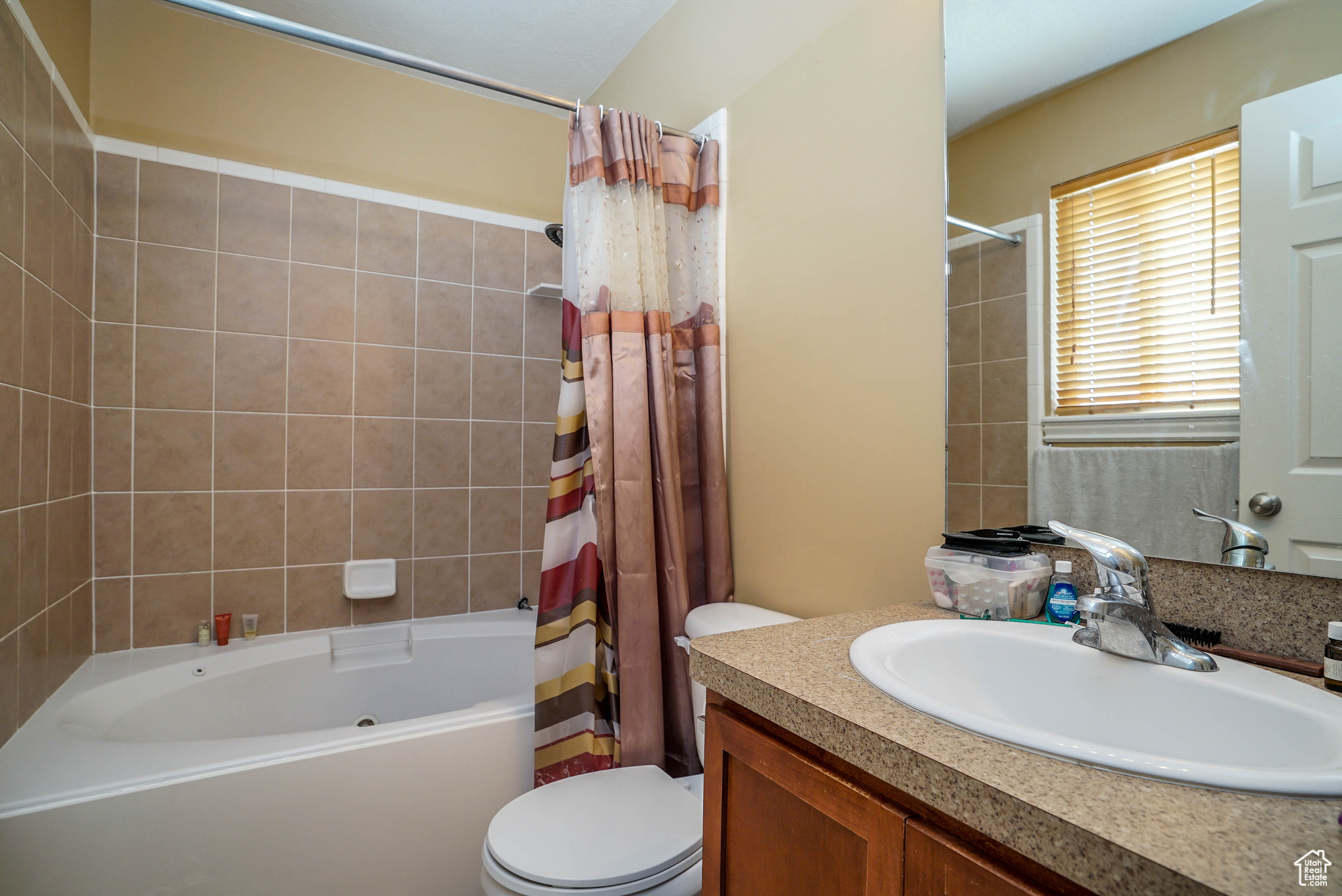 Full bathroom featuring shower / tub combo, vanity, and toilet