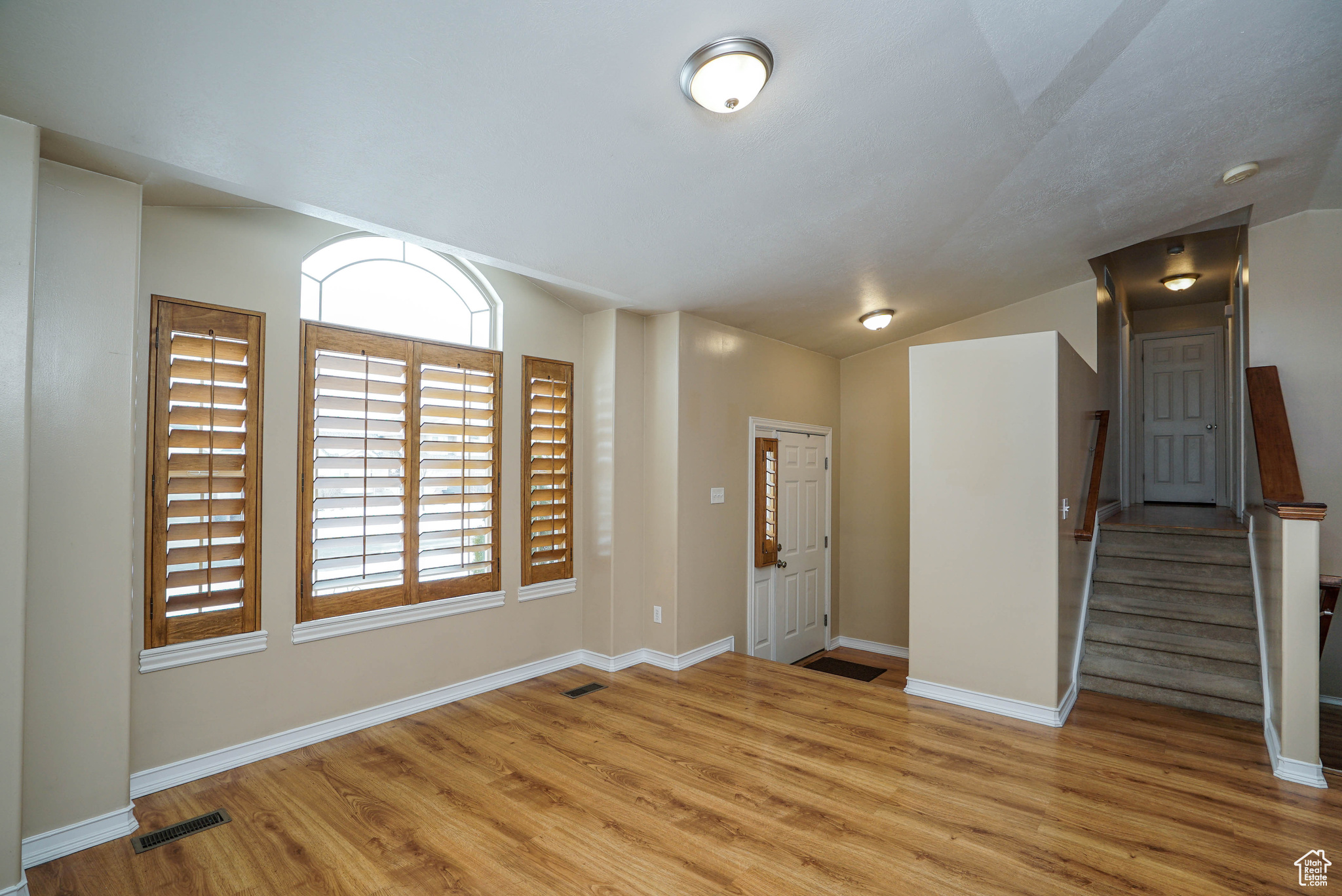 Empty room featuring light hardwood / wood-style flooring and lofted ceiling