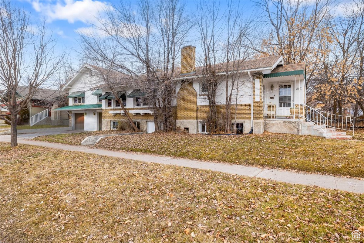 View of front of house with a garage and a front lawn