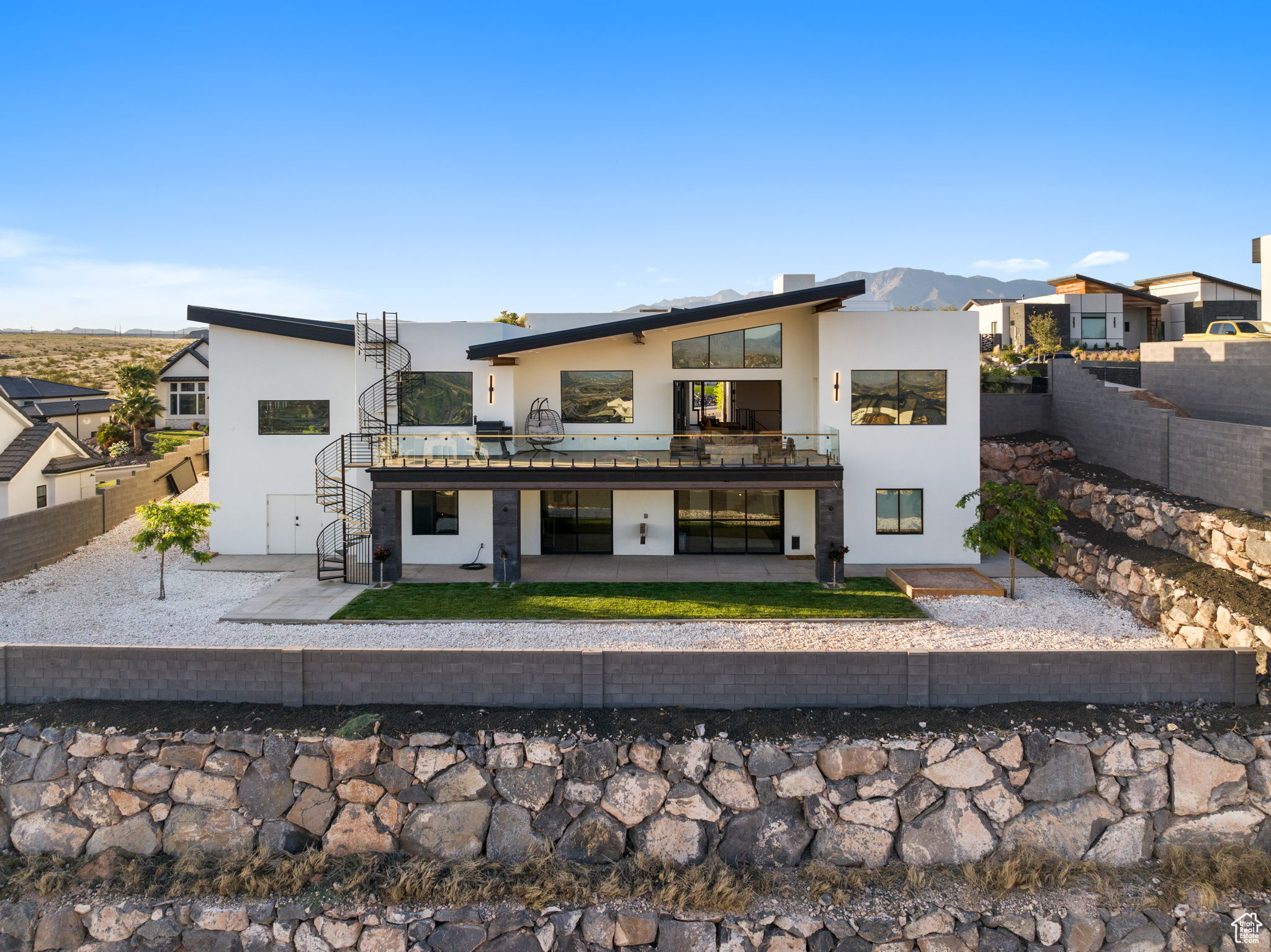 Back of property with a patio area, a mountain view, and a balcony