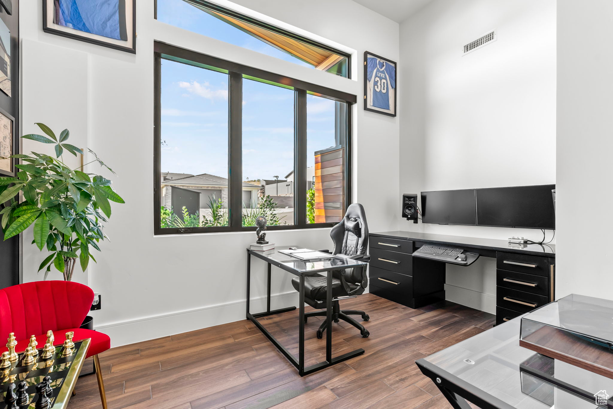 Office space with dark hardwood / wood-style flooring