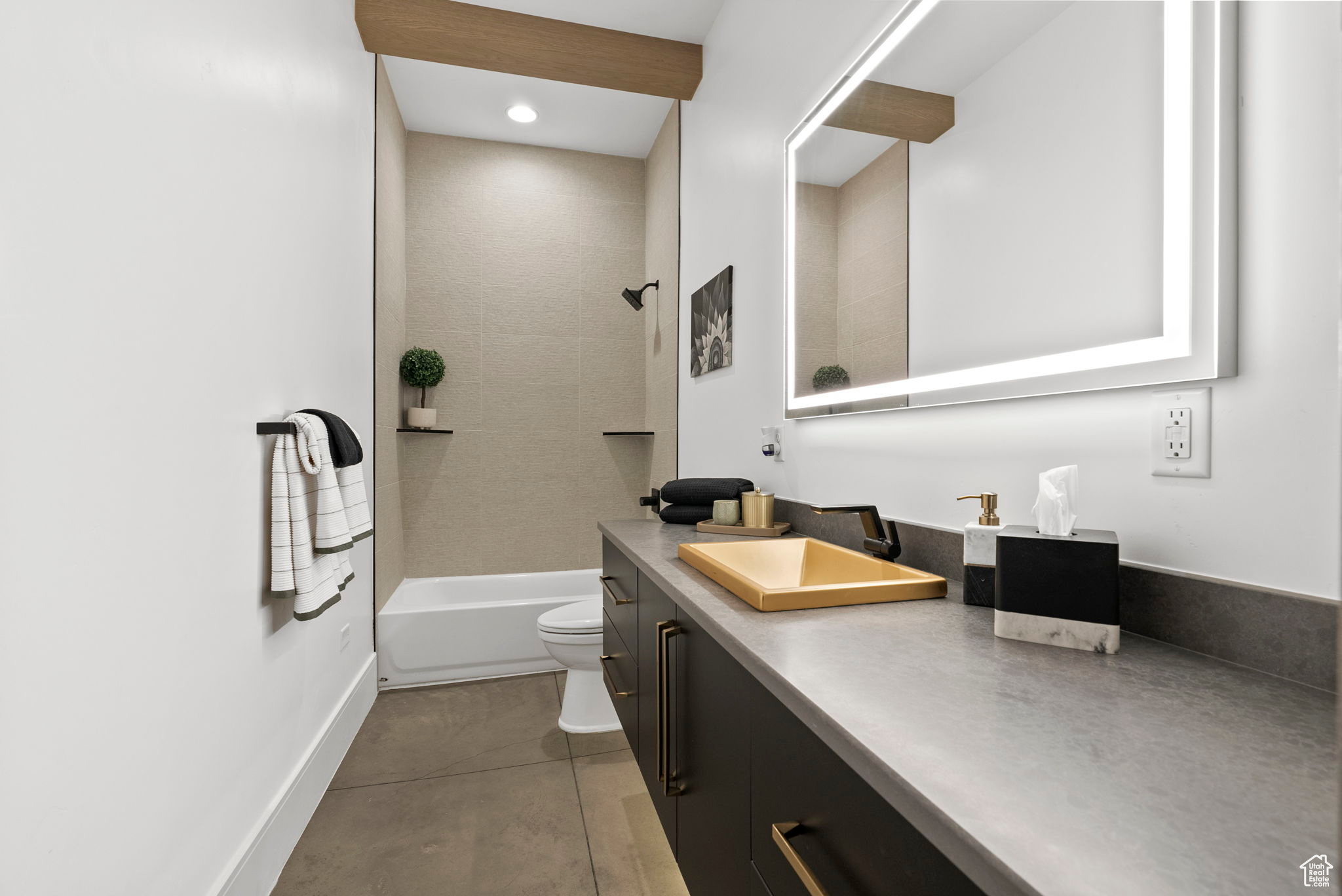 Full bathroom with tile patterned flooring, vanity, toilet, and tiled shower / bath combo