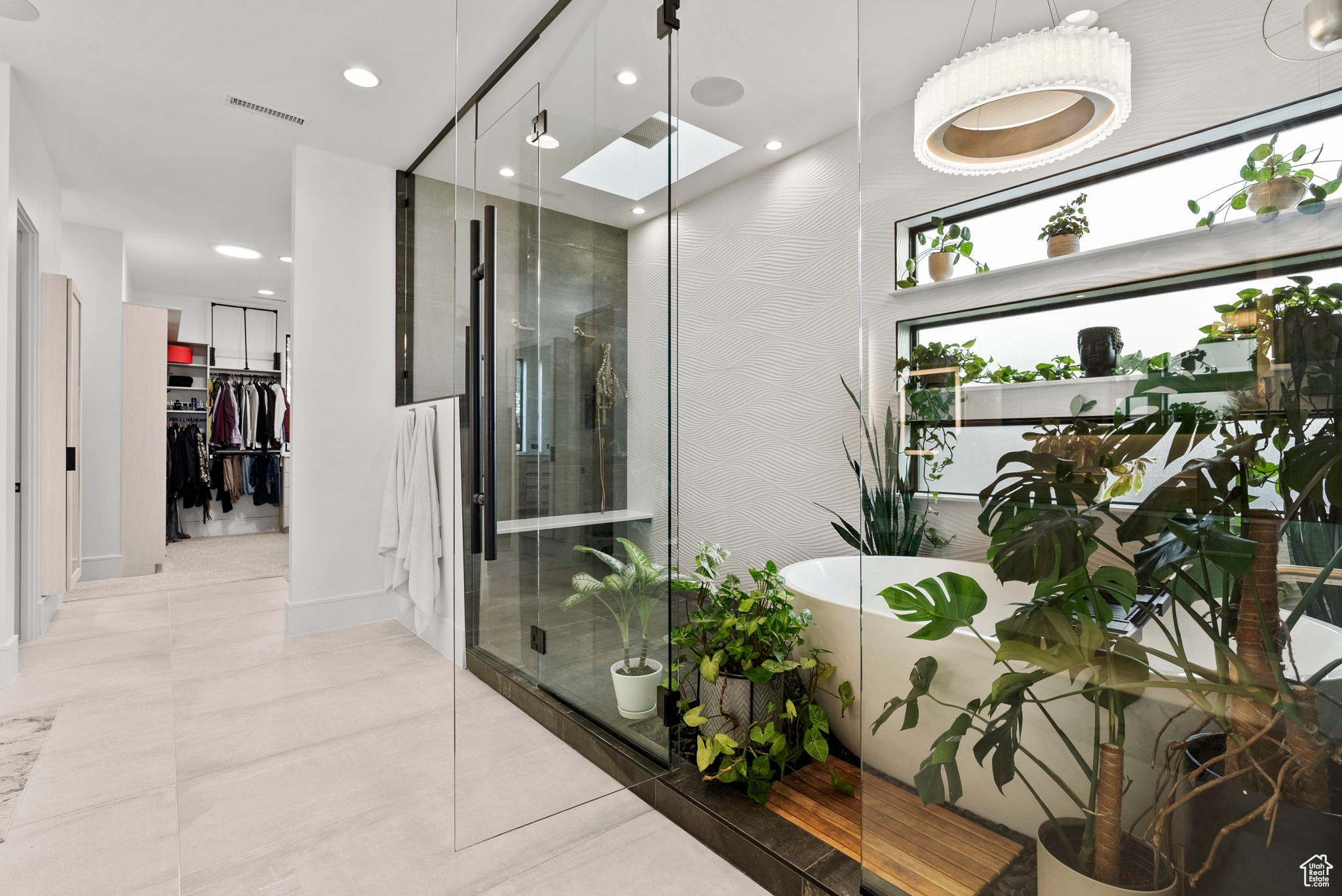 Bathroom featuring a skylight, tile patterned flooring, and independent shower and bath