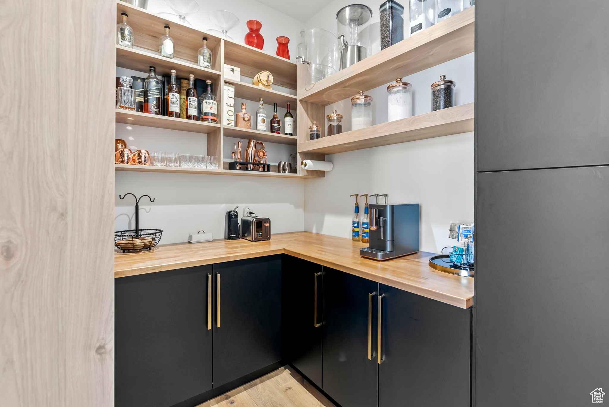 Bar with wood counters, light hardwood / wood-style flooring, and fridge