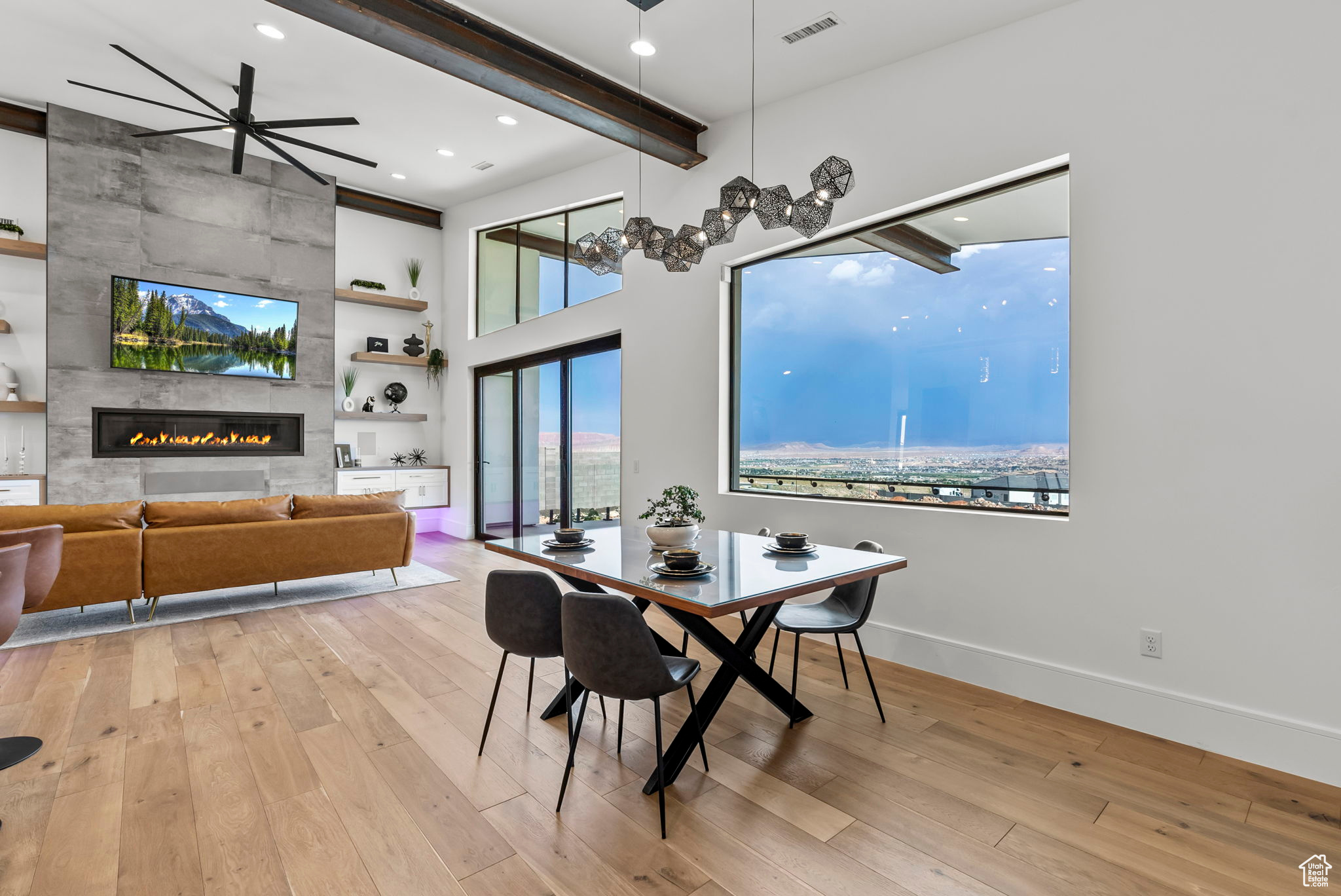 Dining area with ceiling fan, light wood-type flooring, and a tiled fireplace