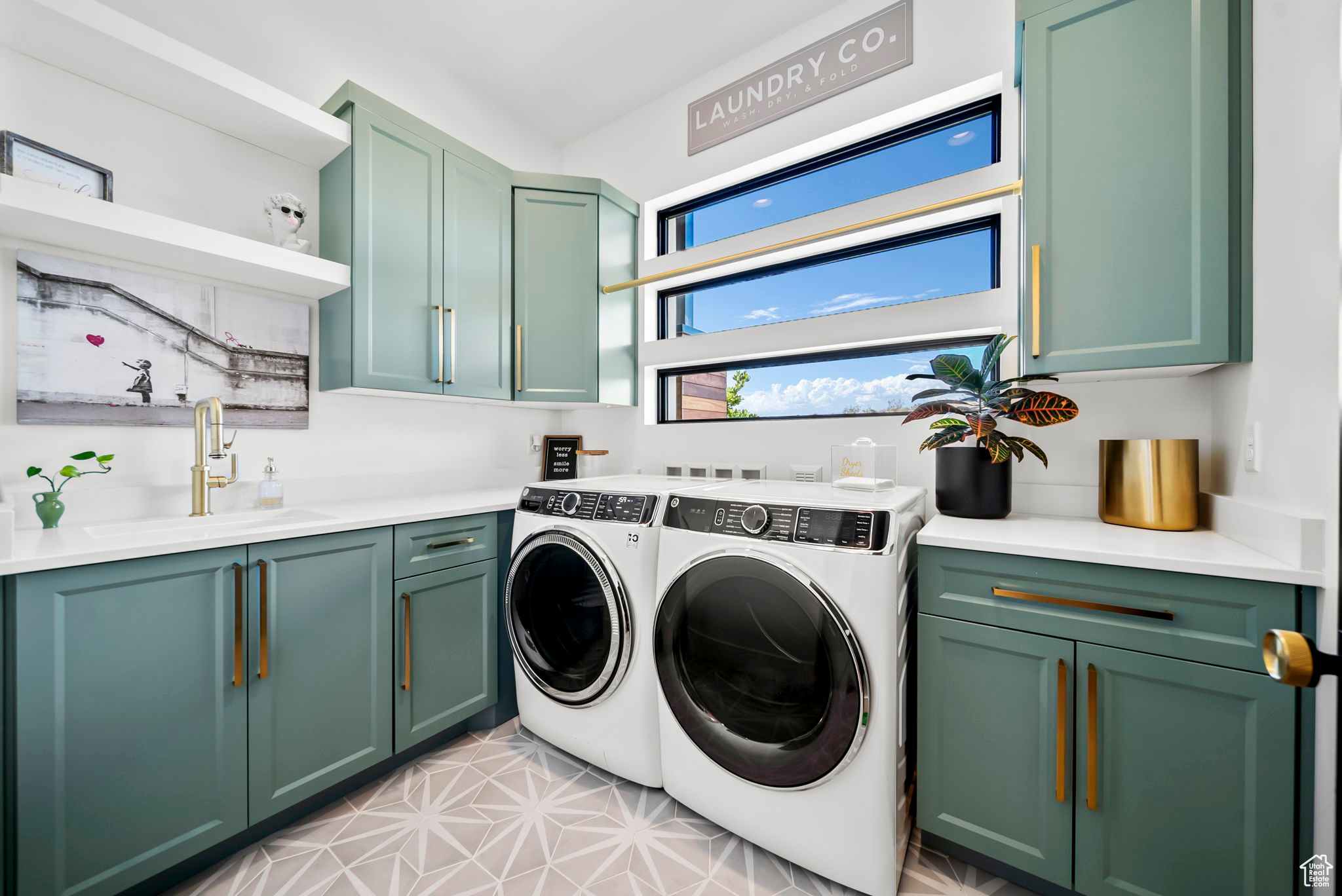 Laundry room with cabinets, washer and clothes dryer, and sink