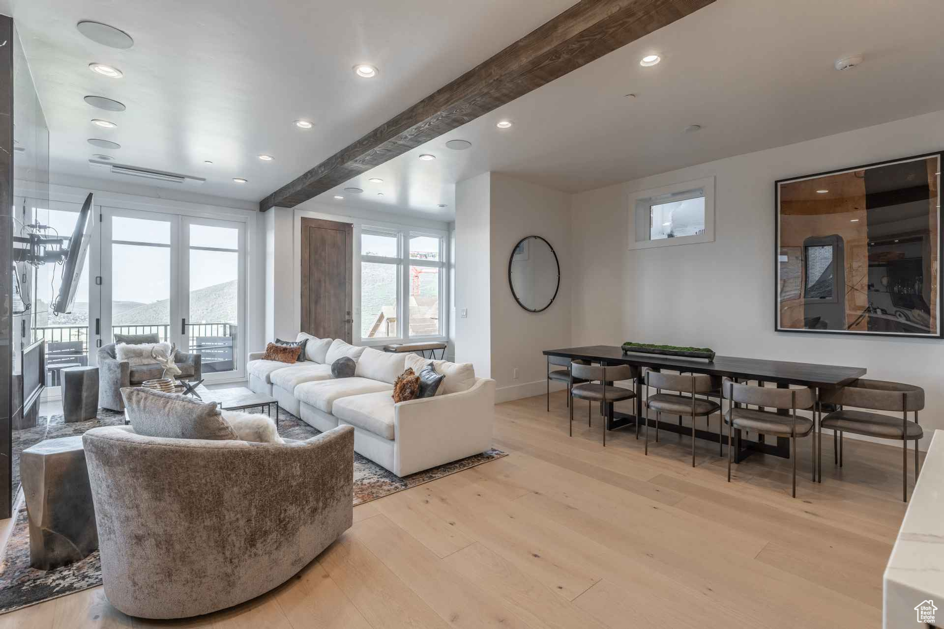 Living room featuring french doors, beamed ceiling, and light wood-type flooring