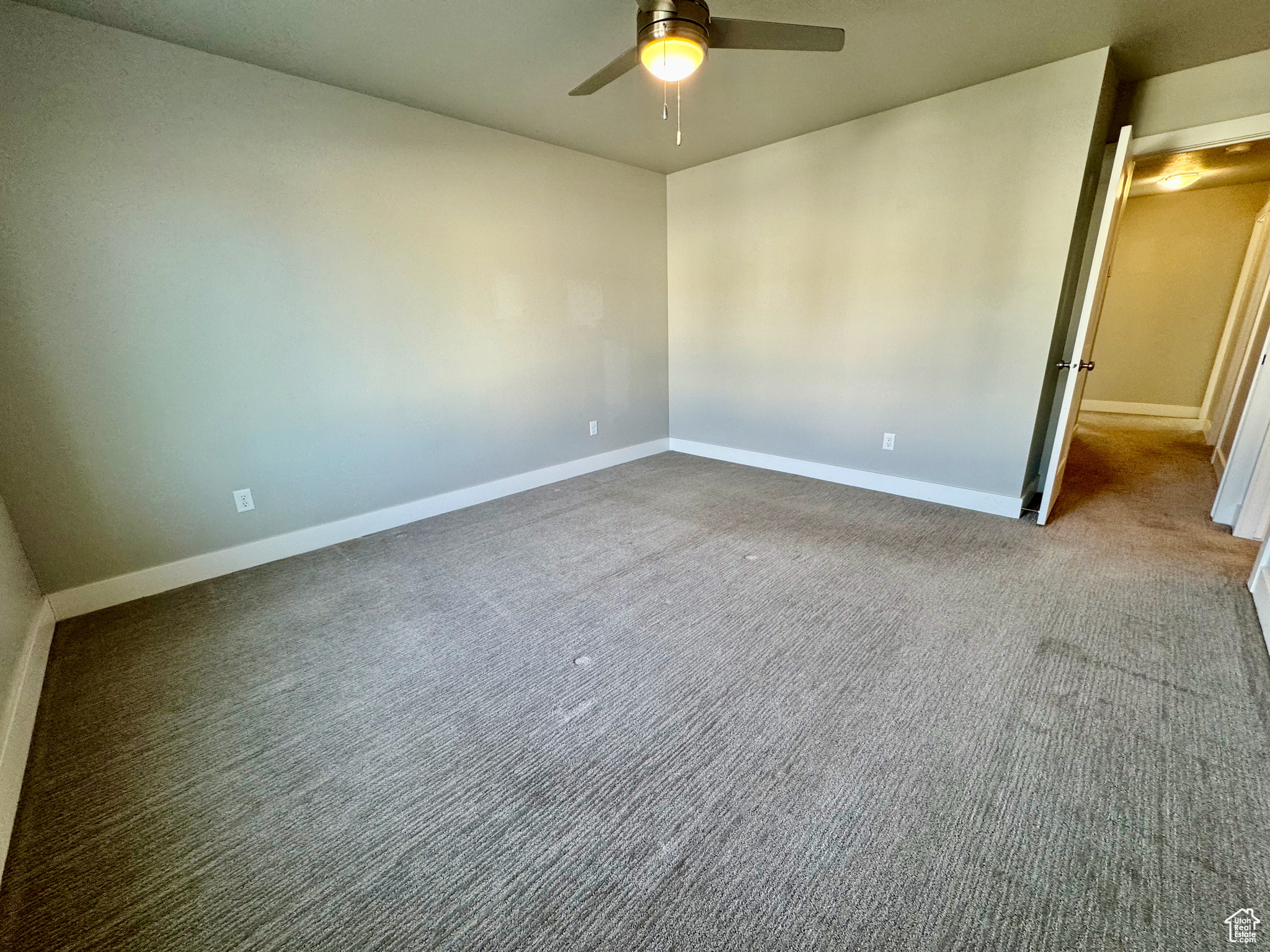 Empty room featuring ceiling fan and carpet